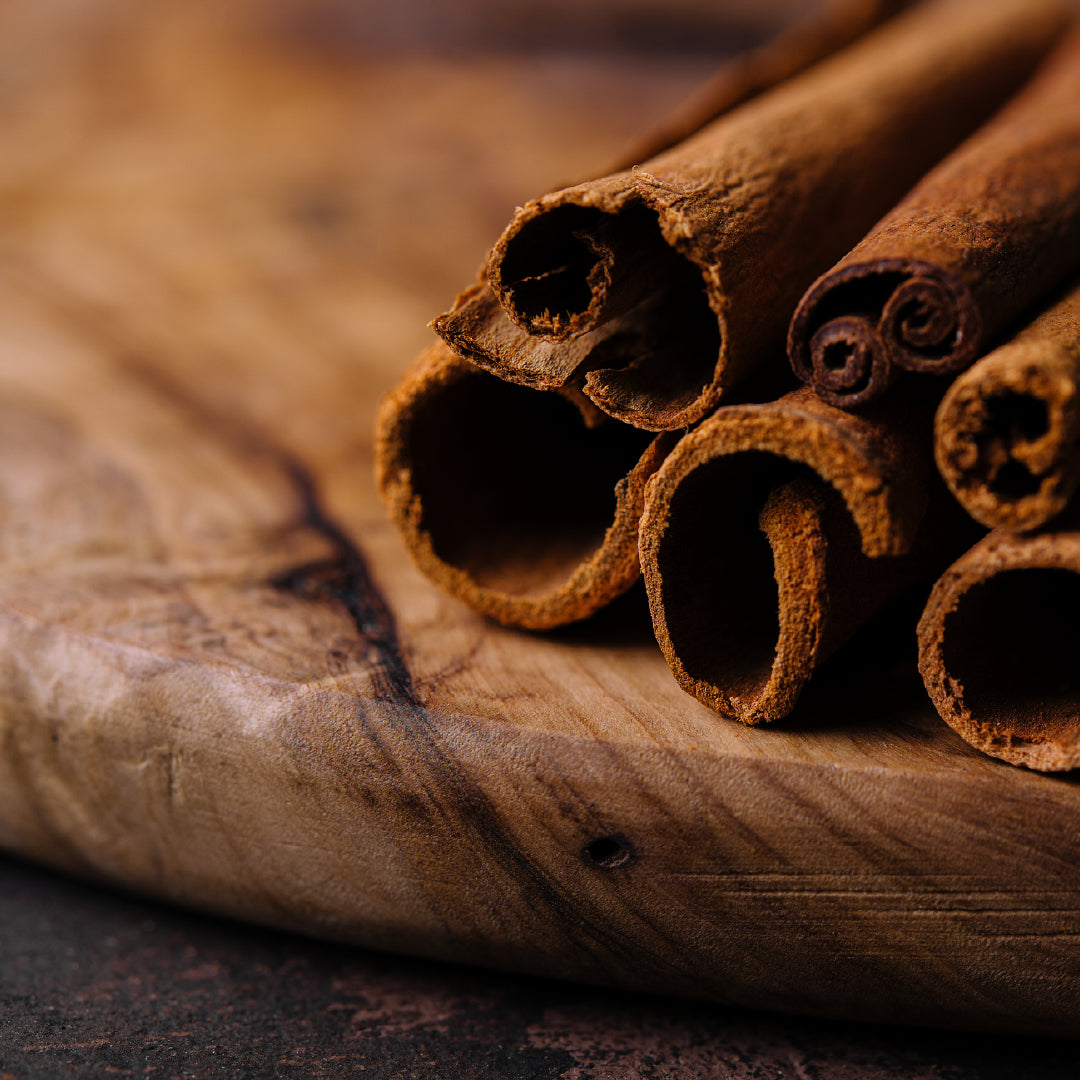 A wooden plate with cinnamon sticks on